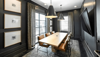 A modern dining room with a wooden table and chairs.